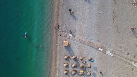 Sommerurlaub-An-Schönen-Stränden-In-Albanien-Sonnen-Sich-Touristen-Unter-Sonnenschirmen-In-Der-Nähe-Von-Türkisfarbenem-Meerwasser