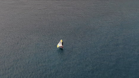drone-shot-from-behind-on-man-doing-windsurfing-in-the-sea