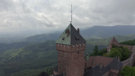 Circulating-aerial-shot-of-a-tower-of-a-renovated-medieval-castle-in-the-Alsace-region-of-France