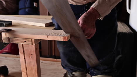Man-Sawing-Wood-In-Garage---close-up
