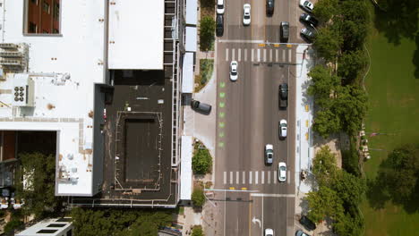 Bird's-eye-aerial-view-traffic-on-busy-urban-street-downtown-Austin-Texas,-drone-4K