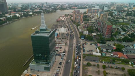 Traffic-and-cityscape-of-Falomo-Bridge,-Lagos-Law-school-and-the-Civic-centre-tower-in-Lagos-Nigeria