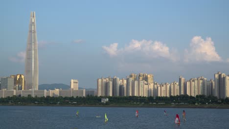 Eine-Gruppe-Von-Männern-Windsurft-Tagsüber-Am-Fluss-Han-In-Der-Nähe-Des-Lotterturms,-Jamsil-bezirk-Von-Seoul-City,-Südkorea