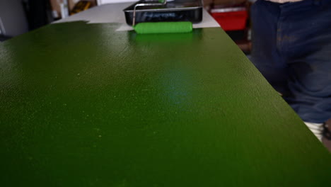 Walzenbürste,-Die-Beim-Lackieren-Der-Tischplatte-In-Der-Garage-Mit-Grüner-Latexfarbe-Verwendet-Wird