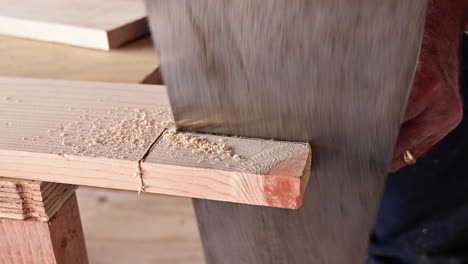 Male-Hands-Sawing-Wood-Plank-With-A-Handsaw