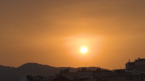 Schöner-Sonnenuntergang-über-Der-Stadt-Mit-Den-Bergen-Im-Hintergrund-Und-Dem-Orangefarbenen-Himmel