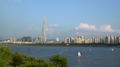 People-Windsurfing-on-Han-river-on-summer-sunny-day,-Lotter-Tower-on-background