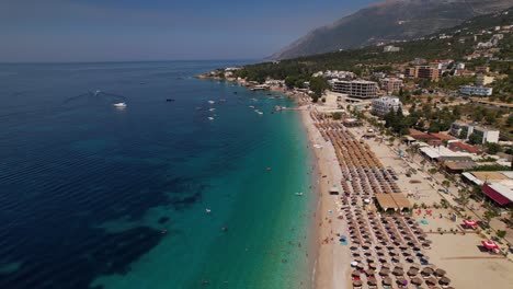 Large-beach-of-Dhermi-with-umbrellas-washed-by-clean-blue-turquoise-water-of-Mediterranean-sea
