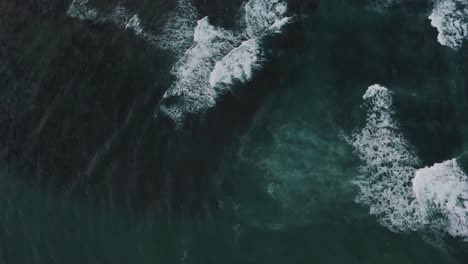 Aerial-top-down-of-crashing-waves-of-blue-Ocean-in-Costa-Rica-during-summer
