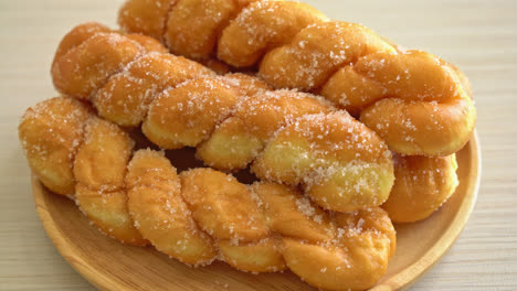 sugar-doughnut-in-spiral-shape-on-wooden-plate