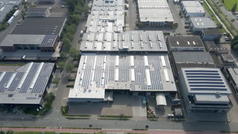 Aerial-tilt-down-to-solar-panels-on-rooftop-of-industrial-buildings
