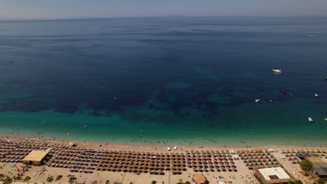 Blue-sea-horizon-and-turquoise-lagoon-near-paradise-beach-with-umbrellas,-vacation-spot-in-Albania