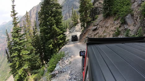 Two-4WD-vehicles-driving-on-trail-cut-into-mountain-side-high-above-Yankee-Boy-Basin-in-the-San-Juan-Mountains-near-Ouray-Colorado