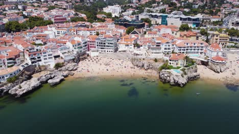 AERIAL-Flying-Backwards-Shot-of-Cascais-Beaches-and-its-Beautiful-Cityscape,-Portugal