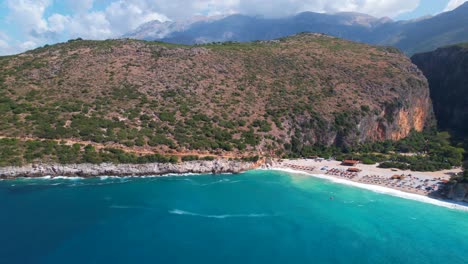 Hermosa-Bahía-De-Gjipe-En-Albania-Con-Agua-De-Mar-Turquesa-Que-Lava-La-Playa-De-Arena-En-Un-Destino-Turístico-Remoto