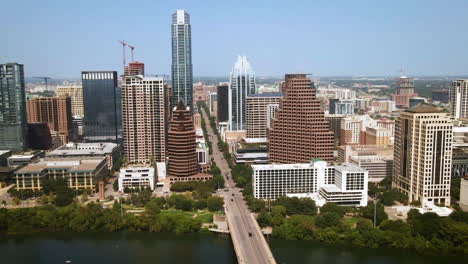 Aerial-view-of-downtown-Austin-from-Lady-Bird-Lake-North-toward-Texas-State-Capitol-Building,-drone-4K