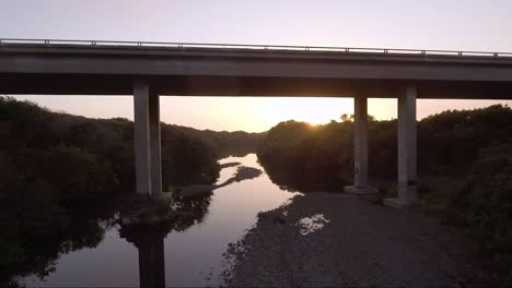 AERIAL---camera-goes-under-bridge-filming-waterway