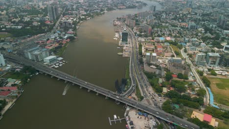 Traffic-and-cityscape-of-Victoria-Island,-Lagos,-Nigeria-featuring-Falomo-Bridge,-Lagos-Law-school-and-the-Civic-centre-tower