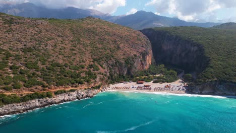 Remote-beach-of-Gjipe-in-Albania,-canyon-filled-with-sand-washed-by-sea-waves-of-Mediterranean