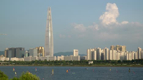 People-windsurfing-on-Han-river-with-Lotte-Tower-on-Background-at-sunset