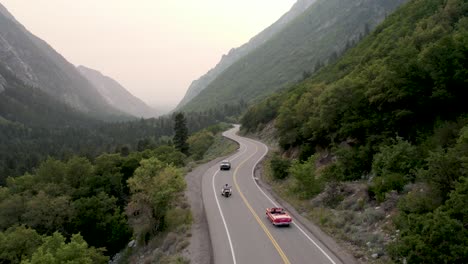 Coche-Convertible-Rojo-Conduciendo-Por-Una-Impresionante-Carretera-Escénica-En-El-Gran-Cañón-De-Cottonwood,-Utah---Antena