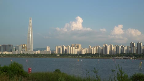 Blick-Auf-Die-Stadt-Seoul-Mit-Windsurfern-Unter-Segeln-Und-Lotter-World-Tower-An-Einem-Bewölkten-Sonnigen-Tag