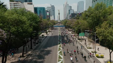 drone-wide-angle-dolly-in-above-cyclists-at-road-near-paseo-de-la-reforma-city