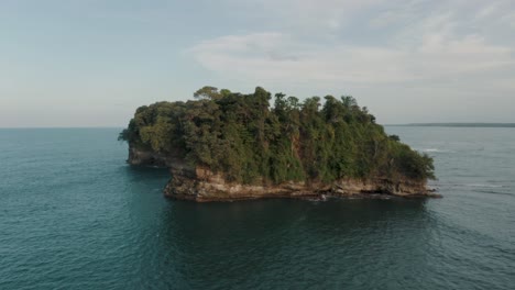 drone-shot-Scenery-Of-Stunning-Sea-around-green-Rocky-Island-With-Dense-Vegetation