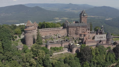 Circulating-aerial-shot-showing-the-full-side-of-a-renovated-medieval-castle-in-the-Alsace-region-of-France