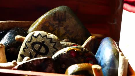 Mysterious-painted-Viking-drawing-patterned-spiritual-stones-colourful-hobby-art-collection-in-wooden-box-with-burning-incense