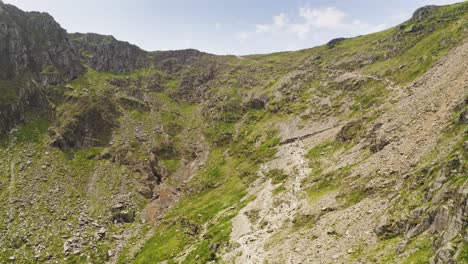Smooth-aerial-descent-past-the-cliff-faces-of-Mount-Snowden-in-Snowdonia-National-Park-in-Wales---Glacial-landforms-makes-for-challenging-hiking-trails-for-visiting-adventurers-and-tourists