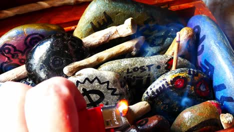 Magical-painted-Viking-drawing-patterned-spiritual-pebbles-colourful-hobby-art-collection-in-wooden-box-with-burning-incense