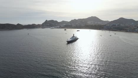 Aerial:-luxury-superyacht-moored-off-Mexican-Pacific-coast-at-sunset