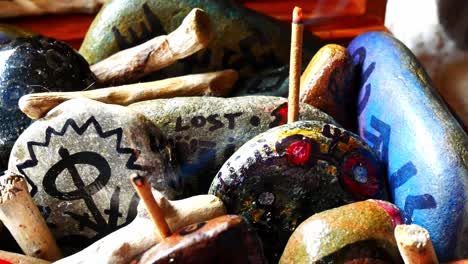 Occult-painted-Viking-drawing-patterned-spiritual-pebbles-colourful-hobby-art-collection-in-wooden-box-with-burning-incense
