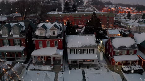 Schnee-Fällt-In-Traditionellen-Zweistöckigen-Amerikanischen-Häusern,-Die-Mit-Winterlichem-Schneefall-Bedeckt-Und-Mit-Weihnachtslichtern-Geschmückt-Sind