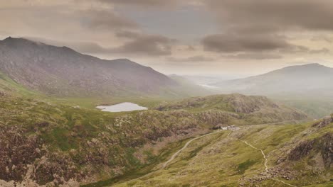 Aerial-Cinematic-smooth-dolly-in-of-Snowdonia-National-Park-Wales-from-Mount-Snowdon-filled-with-drama-and-atmosphere---Wild,-wilderness-and-adventure-concepts---Popular-hiking-trail-for-tourists