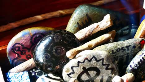 Abstract-painted-Viking-drawing-patterned-spiritual-pebbles-colourful-hobby-art-collection-in-wooden-box-with-burning-incense