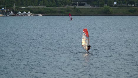 Sunlight-reflecting-in-sail-of-a-person-windsurfing-on-Han-river-near-Ttukseom-Park-on-sunset