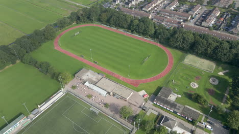 Cinematic-aerial-of-running-track-on-green-sports-field