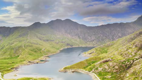 Snowdonia-National-Park-Wales,-Panoramic-trucking-aerial-over-LLyn-Llydaw-Lake-and-the-dramatic-mountain-landscape---Cinematic-drone-footage-of-wild-British-landscapes