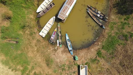 An-aerial-footage-towards-a-docking-key-while-a-Boat-Tour-in-Bueng-Boraphet,-Nakhon-Sawan,-Thailand,-tries-to-move-out-during-a-hot-summer-day