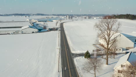 Car-on-curvy-road-through-rural-winter-snow-landscape