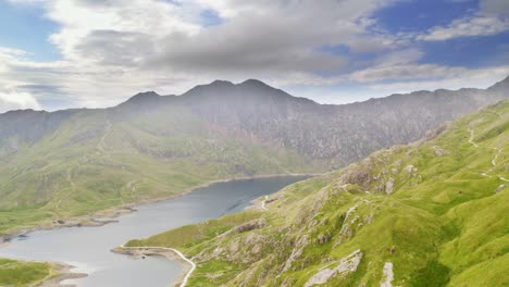 Breathtaking-aerial-pull-out-over-Lake-Llydaw-high-in-the-Snowdonia-National-Park-Wales-with-epic-mountain-range-backdrop
