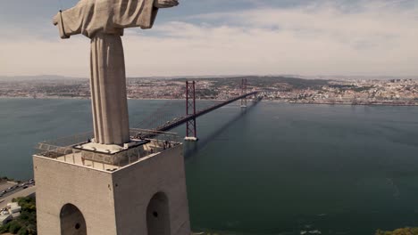 Cinematic-pull-out-from-the-iconic-landmark-sanctuary-of-Christ-the-King-monument-situated-in-Almada