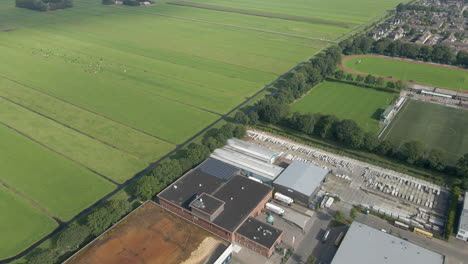 Aerial-of-industrial-site-at-the-edge-of-green,-rural-area
