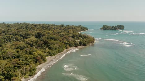 Aerial-view-showing-Coastline-of-Caribbean-Sea-beside-green-deep-Rainforest-and-sandy-Beach---Costa-Rica