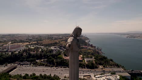 The-outstretched-arms-of-Christ-the-King-sanctuary-towards-the-city-of-Lisbon,-Portugal