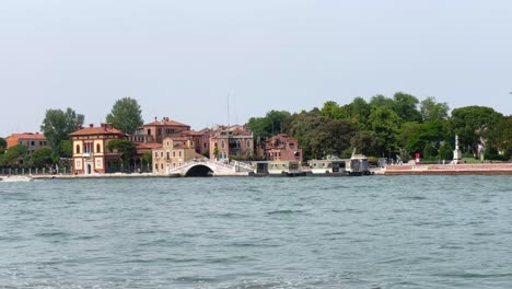 Vista-Desde-El-Agua,-Edificios-Venecianos-Tradicionales-Junto-Al-Paseo-Marítimo