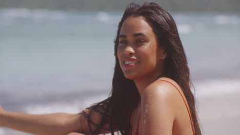 Happy-Smiling-Brunette-Latin-Girl-Relaxing-in-Gentle-Breeze-on-Tropical-Beach,-Portrait-Shot