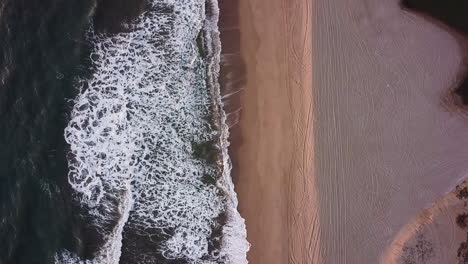 Vertical-air-view-of-waves-hitting-the-beach-with-nobody